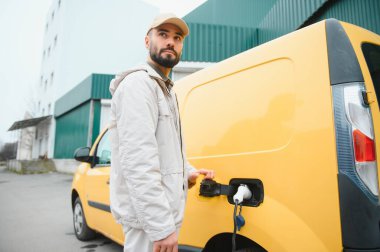 Elektirikli arabayı çalıştıran adam.