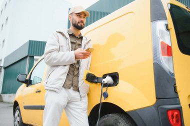 Elektirikli arabayı çalıştıran adam.