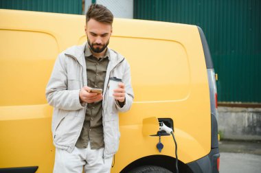 Elektirikli arabayı çalıştıran adam.