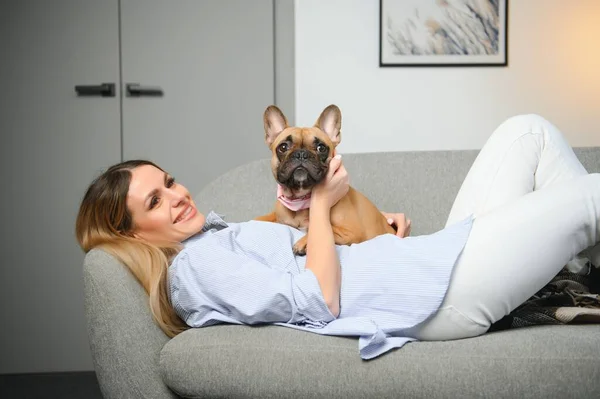 Young woman with her cute dog at home. Lovely pet.