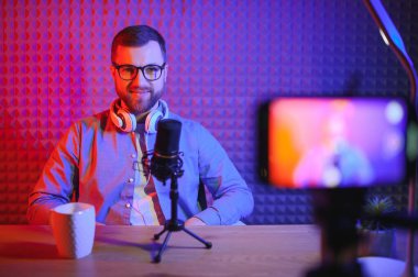 Bir video blogcusu stüdyosundaki içeriği kaydediyor. Sahne arkası fotoğrafı, blogcu hazırlanırken vurulma olayına katılanlardan birinin arkasından çekildi.