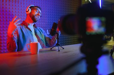 Bir video blogcusu stüdyosundaki içeriği kaydediyor. Video bloğunun sunucusu, abonelerine bir hikaye anlatmak için çok hevesli olan genç bir adam.