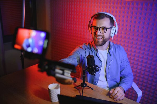 Видеоблогер записывает контент в своей студии. Закулисная фотография была сделана из-за спины одного из участников стрельбы, в начале съемки, когда блоггер готовится