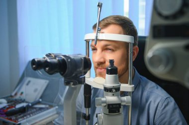 Yakışıklı genç modern göz hastalıkları Kliniği göz imgelemde kontrol ediyor. Hastada göz hastalıkları Kliniği.