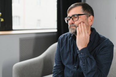 Sanırım dişçiye gitmek gerekiyor. Kıdemli adamın dişleri ağrıyor. Kapatın. Boşluğu kopyala