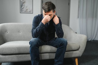 Baş ağrısı. Yaşlı adam evde oturan migren ağrısı çeken masaj tapınaklarından muzdarip. Yaşlılıkta Sağlık ve Sağlık Sorunları Konsepti.