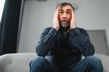 Baş ağrısı. Yaşlı adam evde oturan migren ağrısı çeken masaj tapınaklarından muzdarip. Yaşlılıkta Sağlık ve Sağlık Sorunları Konsepti.