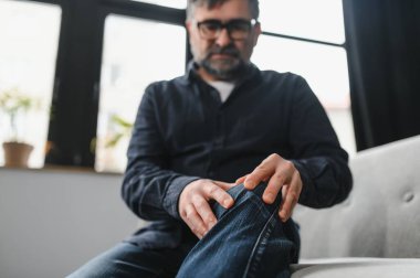 kişi, sağlık ve sorun kavramı - mutsuz üst düzey adam diz acı evde ağrıyor.