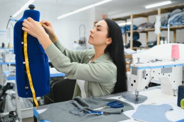 Seamstress at work. Dressmaker making clothes in modern studio