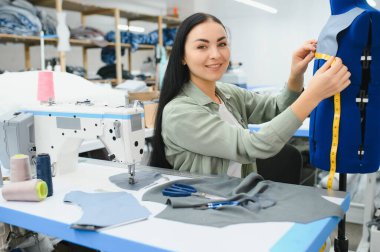 Seamstress at work. Dressmaker making clothes in modern studio