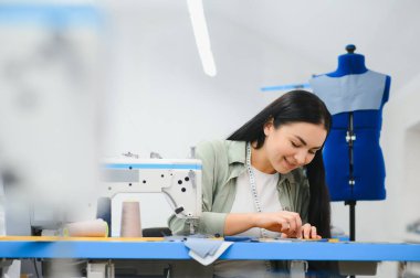 Pozitif genç kadın ile profesyonel makine Atölyesi'nde dikiş