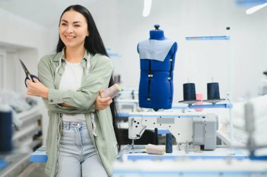 Seamstress at work. Dressmaker making clothes in modern studio