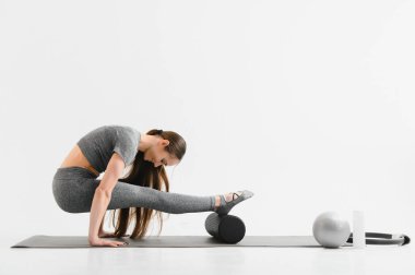 Sexy young female doing exercise on isolated white background.