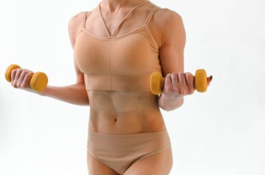 Slim fitness model on a white background. Perfect shape of the female body. Sport, health and diet concept