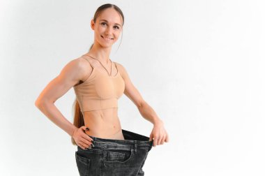 Joyful slim girl showing result of diet.
