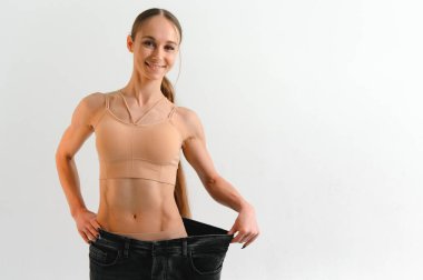 Joyful slim girl showing result of diet.