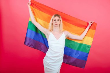 Young transgender woman on red background