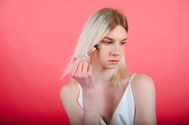 Handsome man wearing make up and woman clothes looking at the camera. positive person