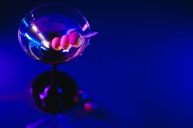 Martini cocktail drink splash with ice cubes in neon iridescent pink and blue colors. Minimal night party life concept