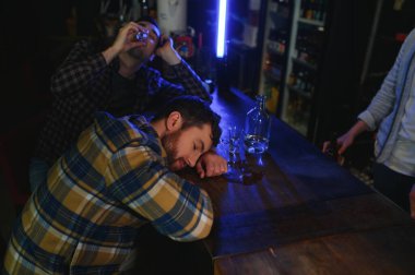 Barda oturan üzgün adam, alkol bağımlısı..