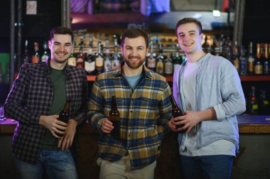 Friends resting in the pub with beer in hands. Having conversation