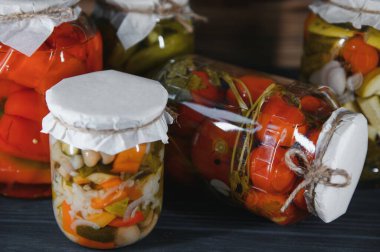 Kırsal ahşap arka planda turşulu sebze kavanozları.