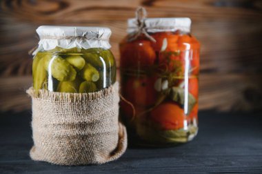 Salatalık turşulu cam kavanozlar (turşu), domates turşusu ve lahana. Çeşitli sebze turşusu kavanozları. Kırsal bir kompozisyonda konserve yiyecekler