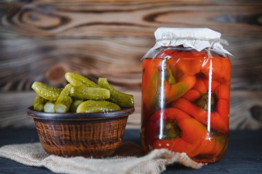 Kırsal ahşap arka planda turşulu sebze kavanozları.