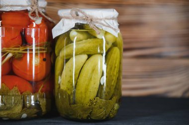 Kırsal ahşap arka planda turşulu sebze kavanozları.