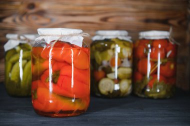 Kırsal ahşap arka planda turşulu sebze kavanozları.