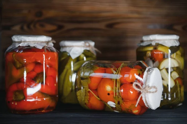 Kırsal ahşap arka planda turşulu sebze kavanozları.