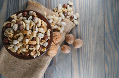 Tahta masadaki fındıklı kasede karışık fındık, fotokopi alanı ile üst manzara