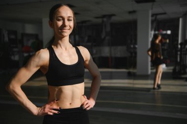 Kusursuz bir beden küme eğitim önce poz jimnastik salonu ile spor giyim esmer seksi fitness kız.