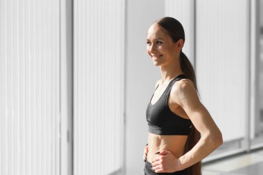 Image of a beautiful strong happy cheerful young sports woman posing at gym.