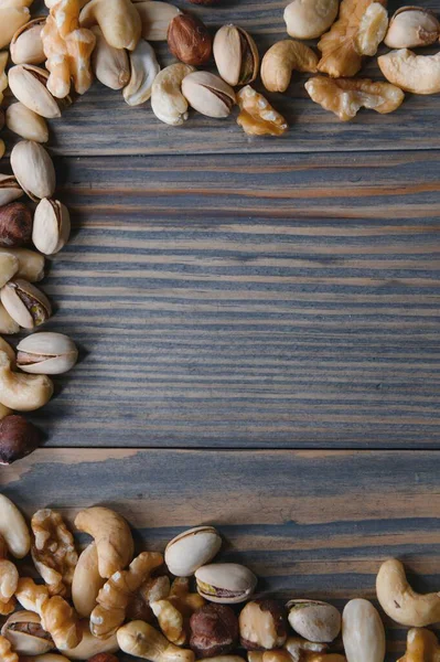 Mixed nuts on wood floor. Organic and fresh nuts. Copy space.