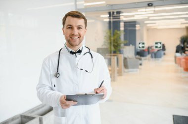 Portrait of smiling doctor in uniform standing in medicine clinic hall.