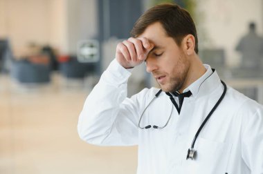 Stressed male doctor. Mid adult male doctor working long hours. Overworked doctor in his office. Not even doctors are exempt from burnout