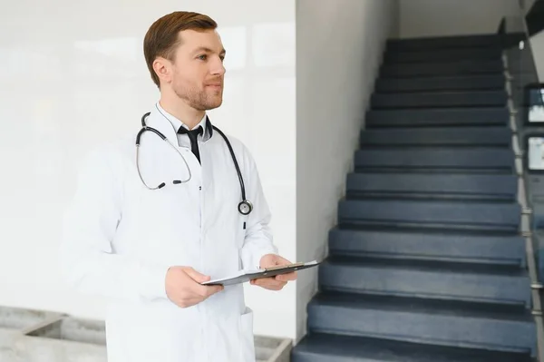 Male Doctor stands in the hall of the hospital.