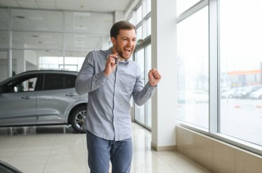 a man chooses a new car for himself walks between the rows in a car dealership.