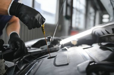Tamirci tamirhanede araba motoru üzerinde çalışıyor. Onarım servisi
