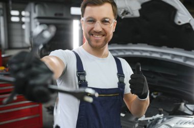 Garajında bir araba motoru tamir gülümseyen portresi.