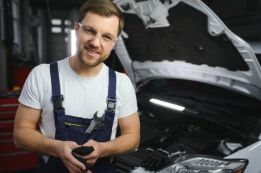 Garajında bir araba motoru tamir gülümseyen portresi.