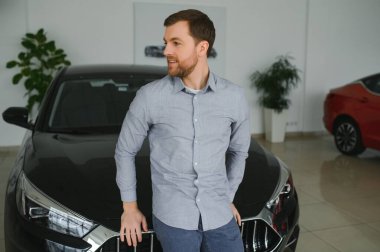 a man chooses a new car for himself walks between the rows in a car dealership.