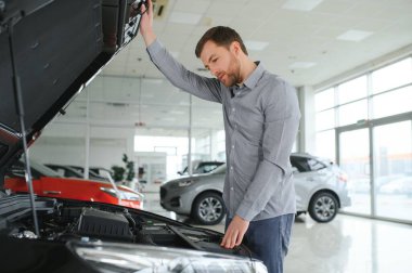 Genç adam yeni bir araç içinde araba Bayilik seçmektir