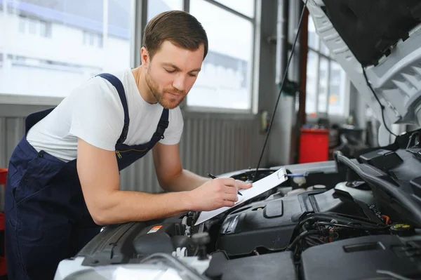Car Mechanic Writing While Holding Clipboard Cars — Stockfoto