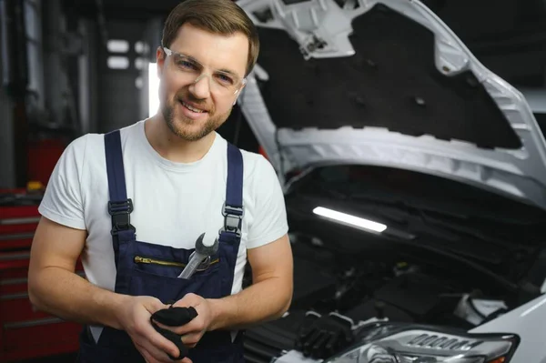 微笑在他的车库里修理汽车的发动机的肖像 — 图库照片