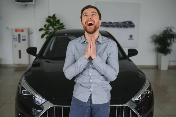 stock image Young man is choosing a new vehicle in car dealership