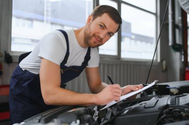 Araba Servisi, tamir, bakım ve insan kavramı - otomatik mekanik adam veya Pano Atölyesi'nde Smith'le gülümseyen mutlu.