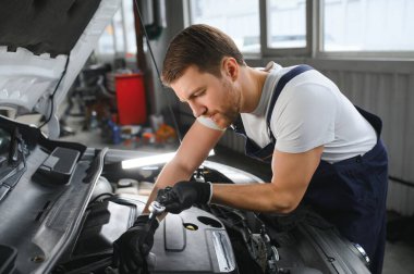 Bir araba servisinde çalışan yakışıklı bir tamircinin portresi çekiliyor. Modern Temiz Atölye