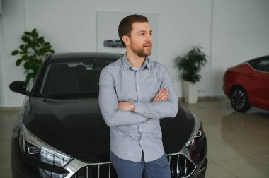 Genç adam yeni bir araç içinde araba Bayilik seçmektir